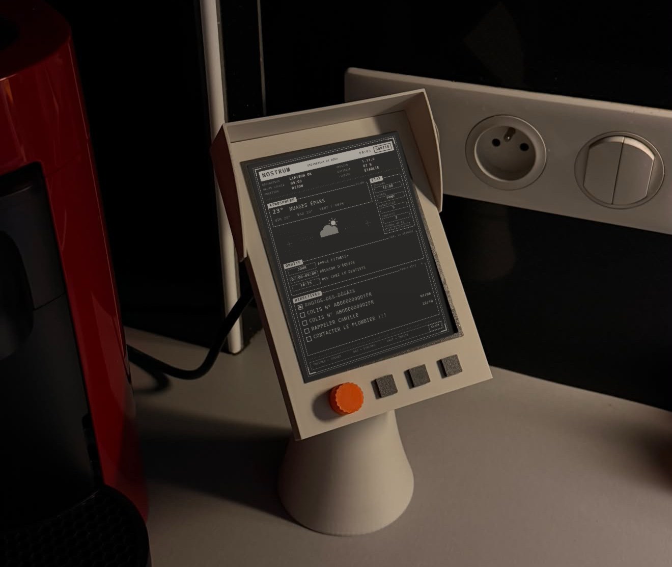 Kindle dans son support imprimé en 3D affichant l'écran Nostrum : météo, rendez-vous du jour et rappels